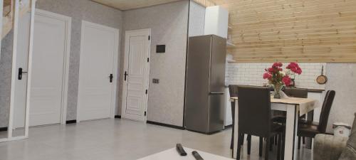 a kitchen with a table with chairs and a refrigerator at A frame Qəçrəş in Qǝçrǝş