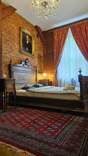 a bedroom with a large bed with a portrait of a man at Łódzki Pałacyk Historic Hotel in Łódź