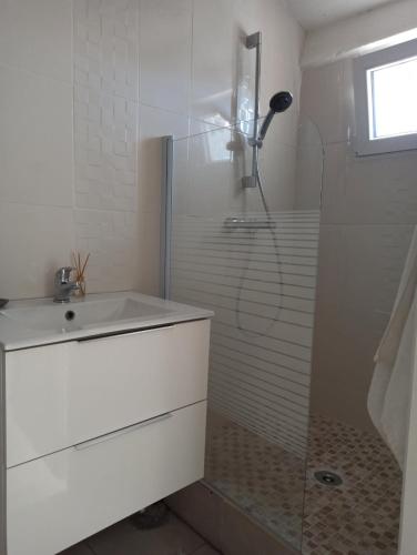 une salle de bain blanche avec une douche et un lavabo dans l'établissement Studio cosy, à Sorgues