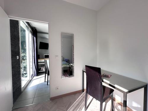 - une salle à manger avec une table et un miroir mural dans l'établissement T2 dans villa plain-pied avec parking privé, à Canet