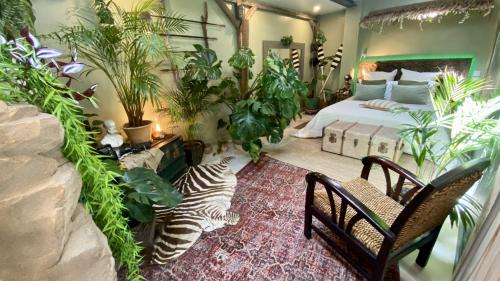 - une chambre avec un lit et beaucoup de plantes dans l'établissement Tropical Lodge SPA Narbonne, à Narbonne