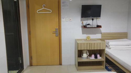 a room with a door and a bed and a television at Asia Travel House in Hong Kong