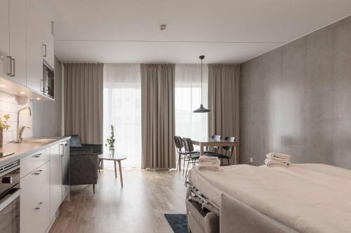 a room with a bed and a kitchen and a table at The More Hotel Västra Hamnen in Malmö