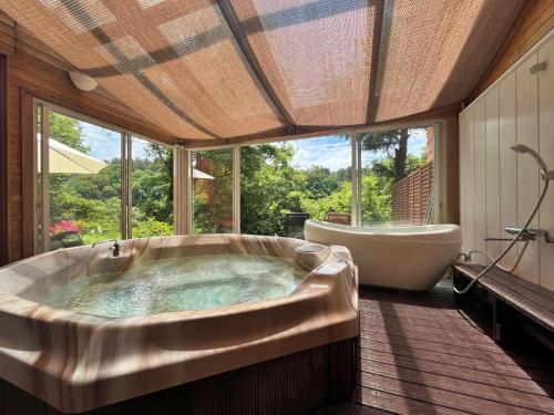a large tub in a bathroom with a bath tub at Pension Asuka inn Daisen in Hoki