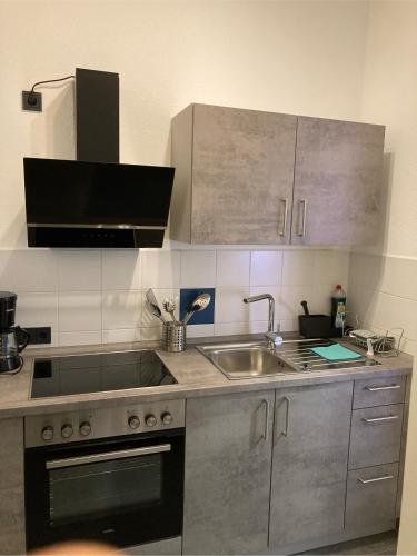 a kitchen with a sink and a stove at Gästehaus Flair in Mettlach