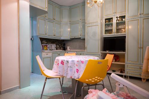 una cucina con tavolo e sedie gialle di Beachfront Family Escape a Nea Kalikratia
