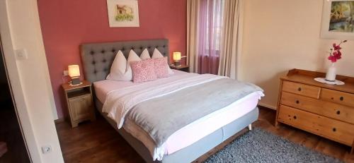 a bedroom with a bed with pink pillows on it at Haus Knapp FeWo Gastein in Dorfgastein