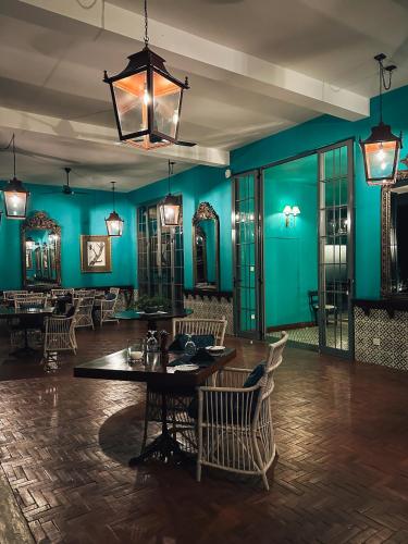 a dining room with blue walls and a table and chairs at Kandy Dendrobium House in Kandy