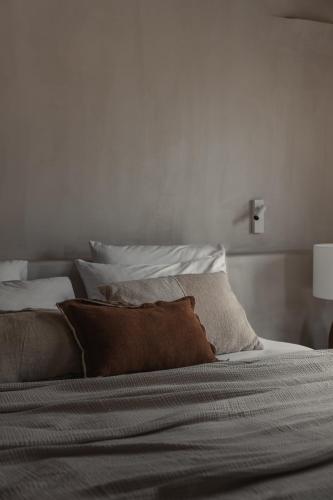 a bed with white sheets and pillows on it at Akria Seaside Suites in Naousa