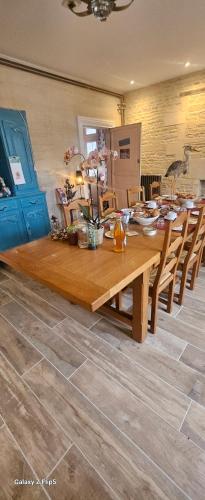 a dining room with a wooden table and chairs at JOYEUX REVEIL in Courseulles-sur-Mer