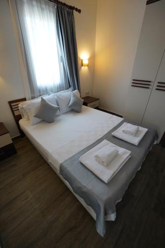 a bedroom with a large white bed with towels on it at Queen Otel in Bodrum City