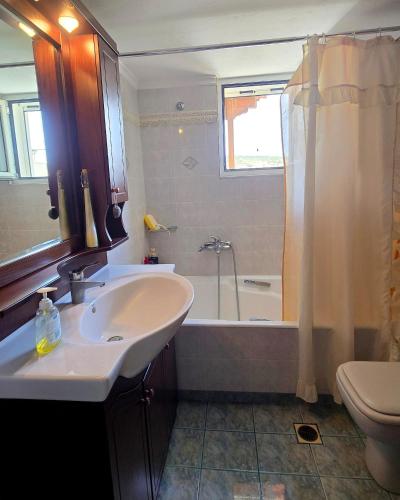 a bathroom with a sink and a bath tub at Annie's summer house in Plytra