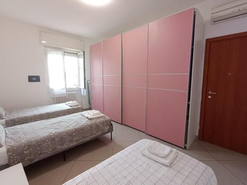 1 dormitorio con 2 camas y armario rosa en A casa di Giulia near Rho Fiera, en Pero