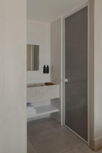 a bathroom with a shower with a glass door at Akria Seaside Suites in Naousa