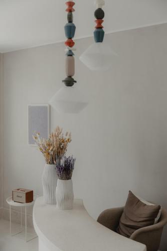 a living room with two vases and a chair at Akria Seaside Suites in Naousa