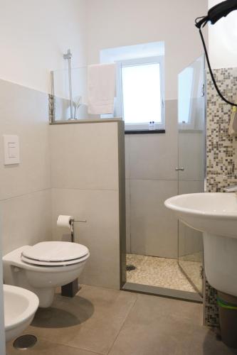 a bathroom with a toilet and a sink at Pharus Miseni Suites and rooms in Bacoli