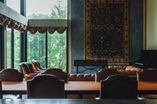 a room with chairs and tables and windows at 森寧monet in Minami Aso