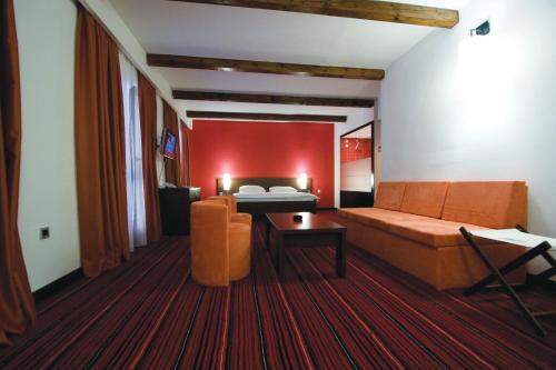 a hotel room with a bed and a couch and a table at Hotel Villa Donat in Sveti Filip i Jakov