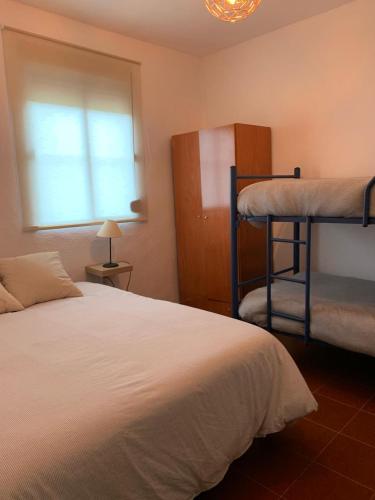 a bedroom with two bunk beds and a window at Casa rural Arroyo Marco in Guadalcanal