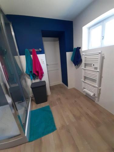 a room with a blue wall and a door and a window at La campagne in La Croisille-sur-Briance