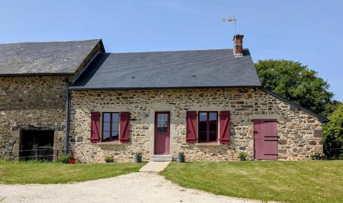an old stone house with red doors and windows at La campagne in La Croisille-sur-Briance