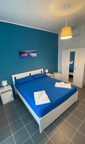 a blue bedroom with a bed and a blue wall at A 100 passi dal mare in Bari