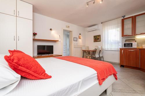 a bedroom with a large white bed and a kitchen at Villa Alegria Cavtat in Cavtat