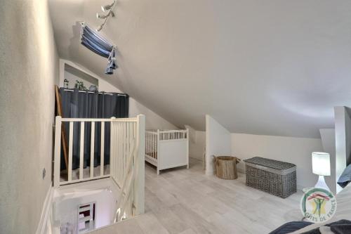 a room with a staircase with a crib and a baby crib at Les petites landes in Pleumeleuc