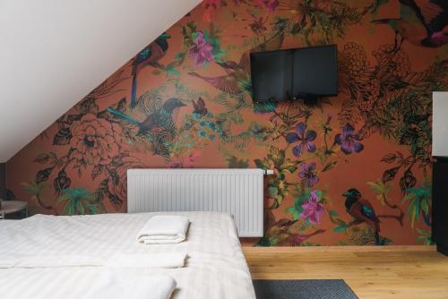 a bedroom with a wall with a floral wallpaper at Lilija apartments in Trzin