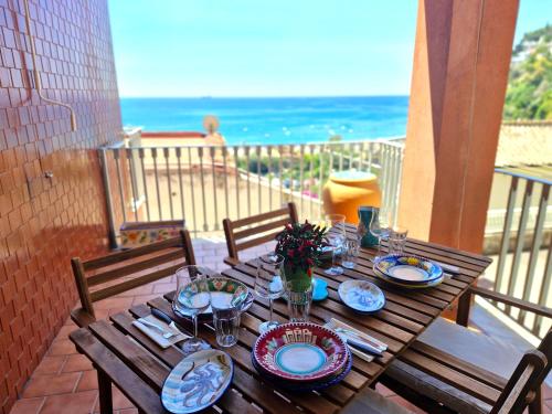 a wooden table with plates of food on a balcony at Casa Delia, apartment close the sea in Vietri sul Mare