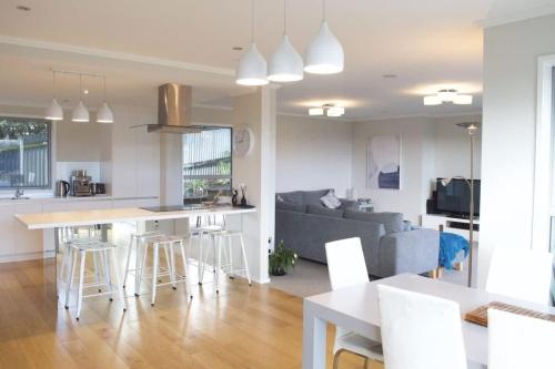新普利茅斯Magic on Molesworth - 2BR townhouse near CBD的配有桌子和沙发的厨房和客厅