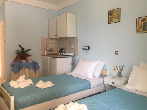 a small room with two beds and a kitchen at Tzakis Studios Lassi in Argostoli