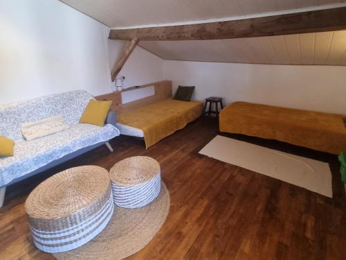 une chambre avec deux lits, un canapé et une table dans l'établissement Le soleil couchant en Périgord, à La Gonterie-Boulouneix