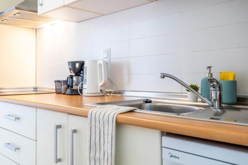 a kitchen with white cabinets and a sink at Casa Albatros - Poolside Retreat in Torre-Pacheco