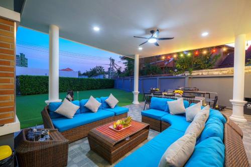 a patio with blue couches and a table at Kate Pool Villa Jomtien Pattaya in Pattaya