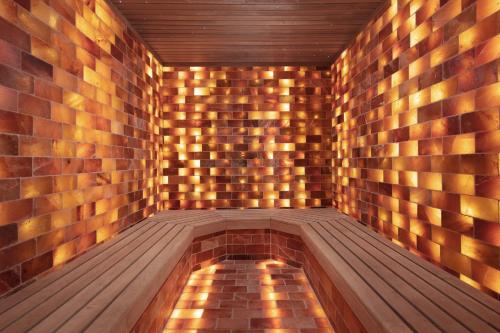 a sauna with a wooden floor and a brick wall at Courtyard by Marriott Prishtina in Pristina