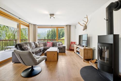 a living room with a couch and a television at Chalet Les Rahâs by Mrs Miggins in Grimentz