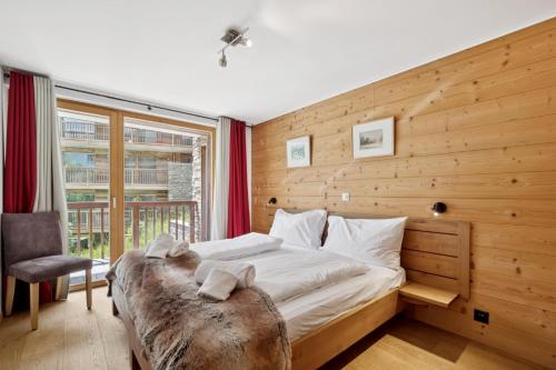 a bedroom with a large bed and a window at Chalet Les Rahâs by Mrs Miggins in Grimentz