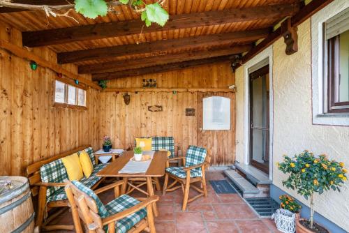 a patio with a table and chairs on a porch at Komfort Apartment Römersberger - 6 in Vogtareuth