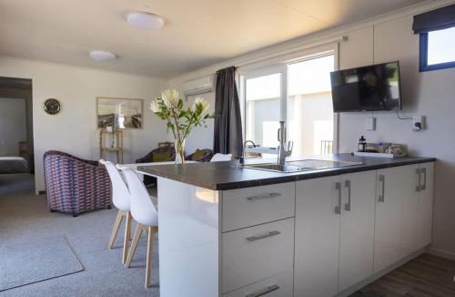 cocina con armarios blancos y encimera con fregadero en Sunny Ark Apartment - modern 1BR apartment, en New Plymouth