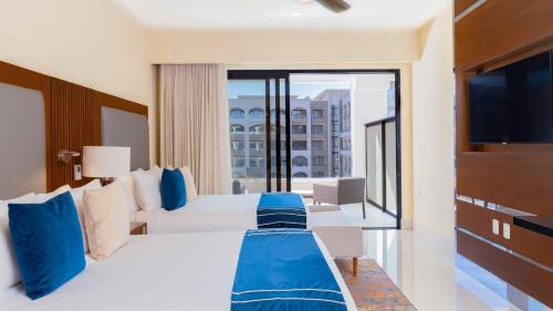 une chambre d'hôtel avec un grand lit et un balcon dans l'établissement Cabo Private Suites by Stephen Ostler Elite Luxe Member, à San José del Cabo