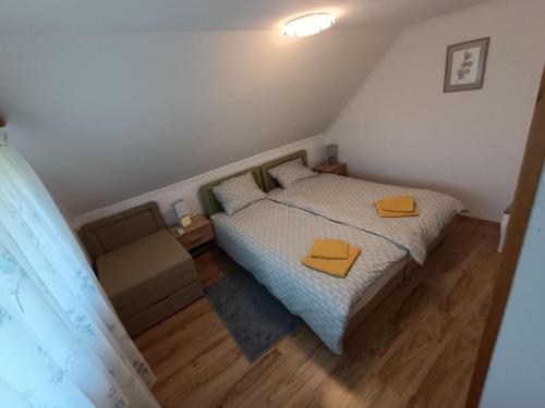 a small bedroom with a bed and a chair at Panoramic house in Szigliget in Szigliget