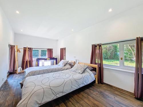 a bedroom with two beds and a large window at Le Chalet NaturZen in Hastière-par-delà