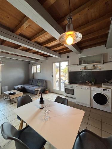 une cuisine et un salon avec une table et des chaises dans l'établissement Charmante maison en Provence, à Châteaurenard