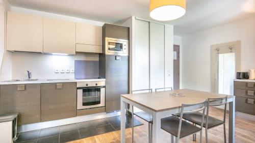 une cuisine avec une table et des chaises dans une pièce dans l'établissement Coeur des ours B N07 - 2P4, à Les Deux Alpes