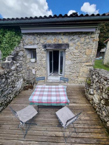 - une table de pique-nique et 2 chaises sur une terrasse en bois dans l'établissement Le soleil couchant en Périgord, à La Gonterie-Boulouneix