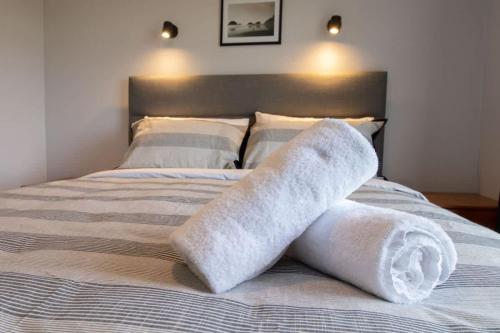 a bed with two rolled up towels on it at The Window Seat - pet-friendly 1BR apartment in Waitara