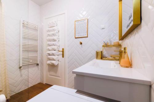a white bathroom with a sink and a shower at Spa Garden Lounge in Mali Lošinj