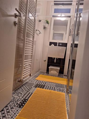 a bathroom with a shower and a yellow and black floor at Plitvice Green Gold Apartments in Korenica