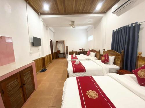 a hotel room with four beds and a flat screen tv at Luangprabang That Luang Boutique House in Luang Prabang